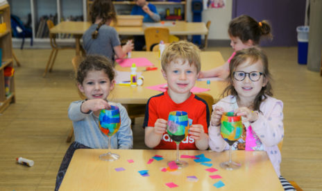 Three preschool kids making crafts