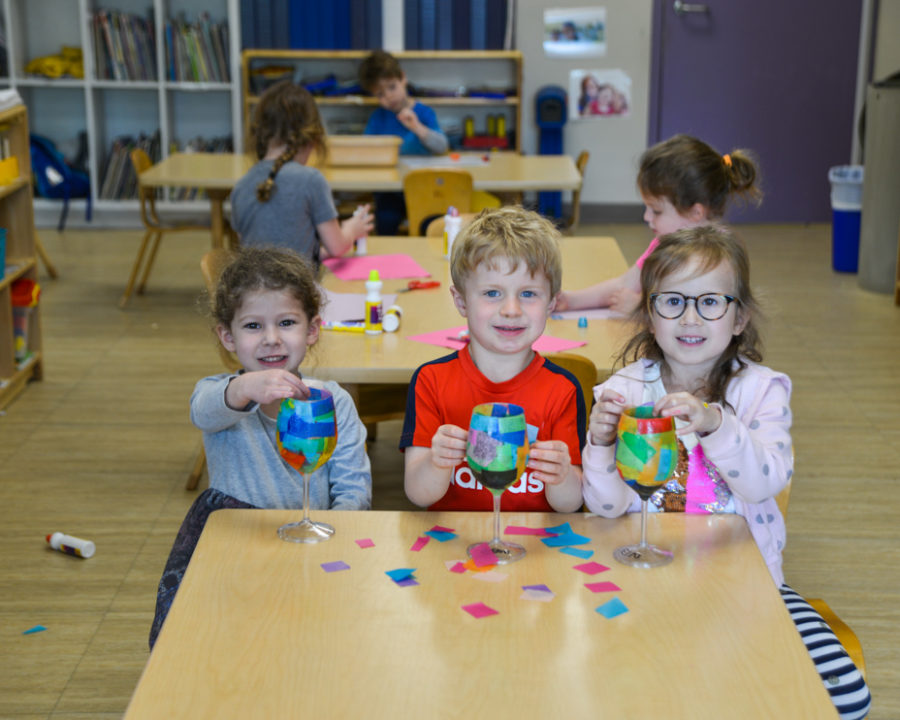 Three kids playing with toys in preschool