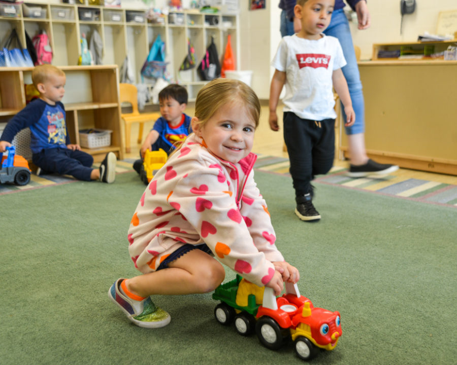 Young girl playing with a toy truck