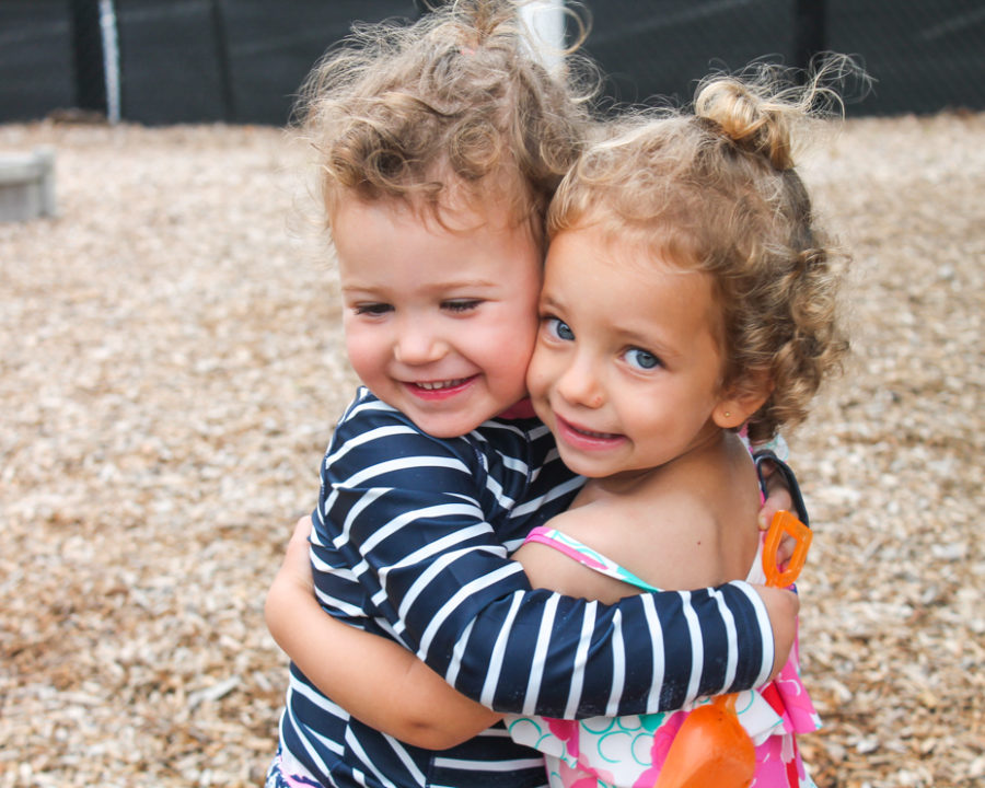 Two preschool friends hugging