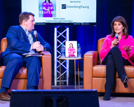 Two speakers in chairs on stage