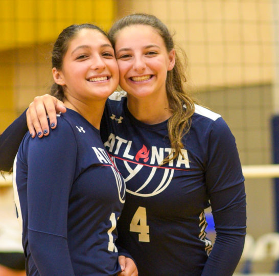 Two volleyball players smiling for a photo