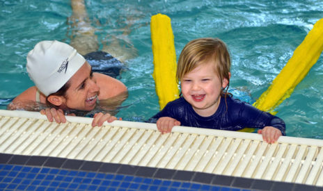 Staff teaching a toddler how to swim