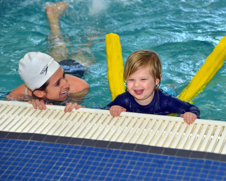 Staff teaching a toddler how to swim