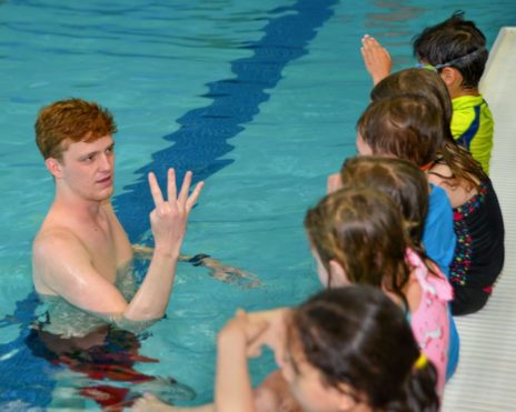 Staff teaching toddlers how to swim