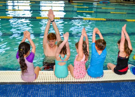Staff teaching toddlers how to swim