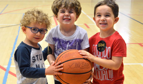 Three kids holding a basketball