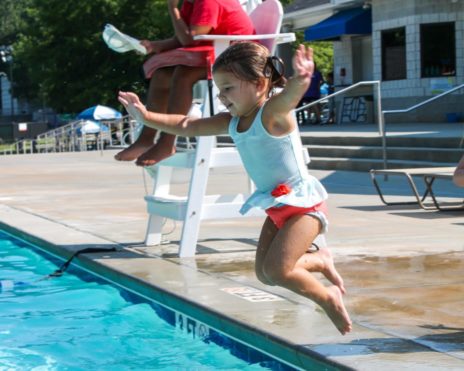 Young child jumping into a pool at Preschool Summer Camp