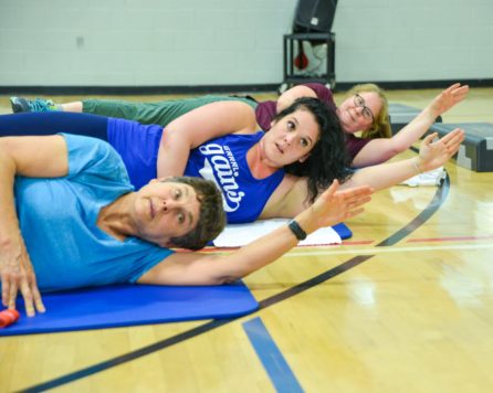 Teens laying on a floor exercising