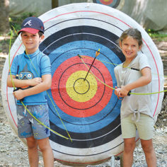 two kids at an archery range